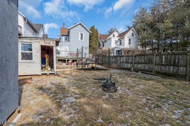 view of yard featuring a trampoline and a deck