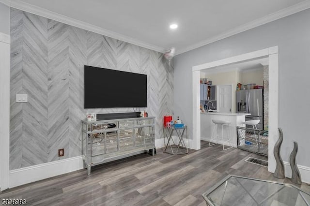 living room with hardwood / wood-style floors, sink, and ornamental molding