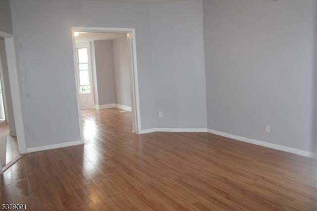 empty room featuring baseboards and wood finished floors