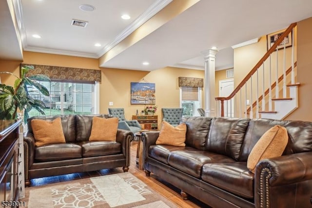 living room featuring light hardwood / wood-style floors, ornate columns, and ornamental molding