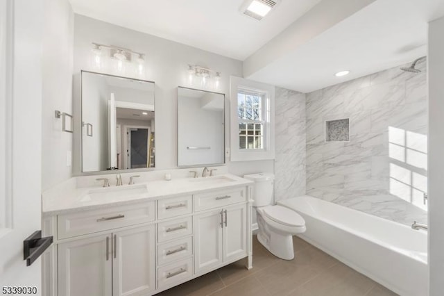 full bathroom with visible vents, a sink, toilet, and double vanity