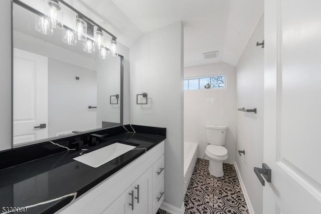 full bathroom featuring toilet, visible vents, vanity, vaulted ceiling, and a tub