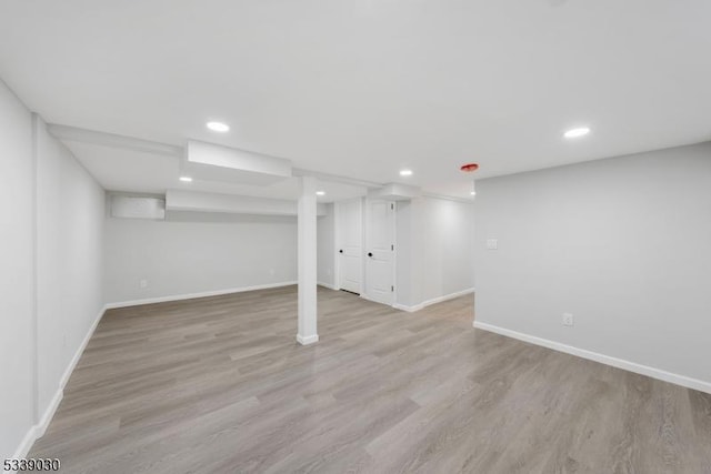 finished basement with light wood-style flooring, baseboards, and recessed lighting