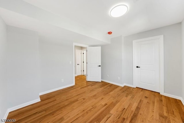 unfurnished bedroom featuring light wood-type flooring and baseboards