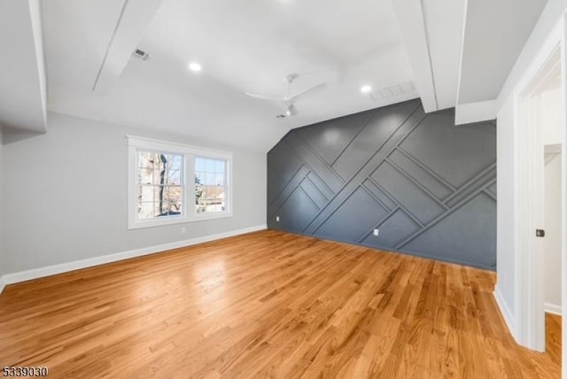 additional living space with visible vents, light wood-type flooring, a ceiling fan, and baseboards