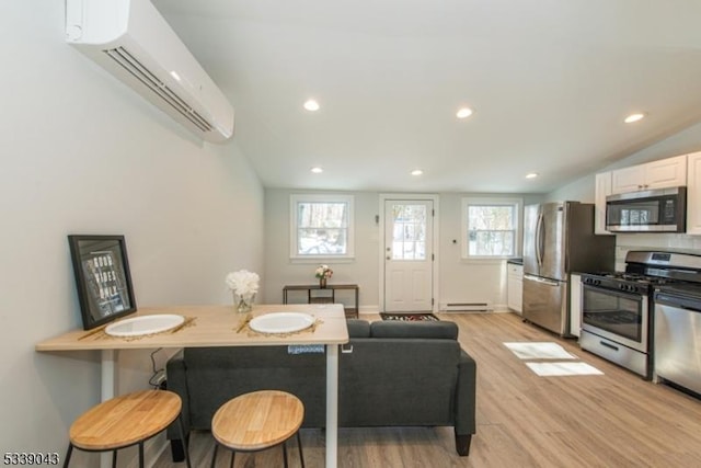 kitchen featuring white cabinetry, a healthy amount of sunlight, stainless steel appliances, and a breakfast bar