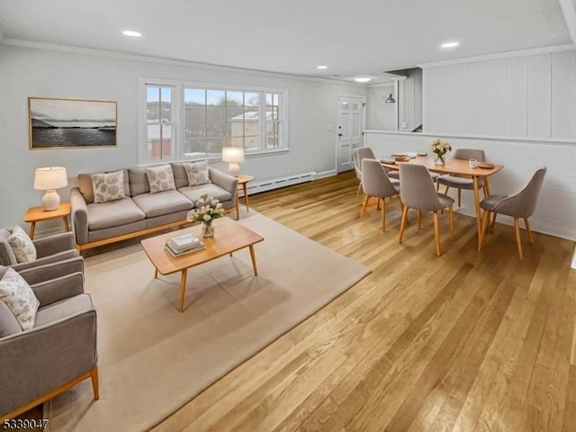 living room with light wood-type flooring, baseboard heating, and ornamental molding