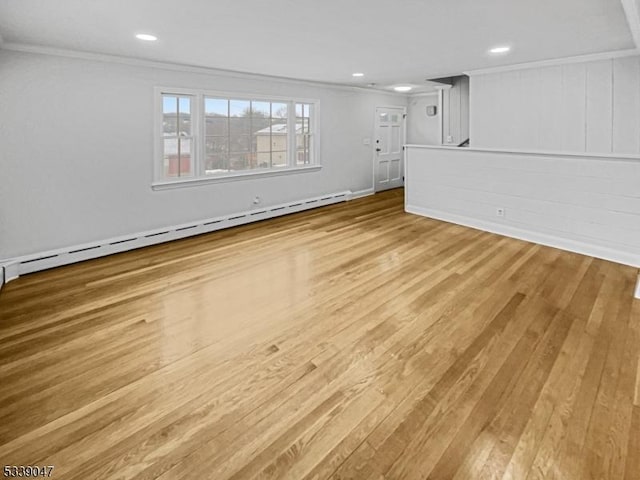 interior space with light wood-type flooring, crown molding, and baseboard heating