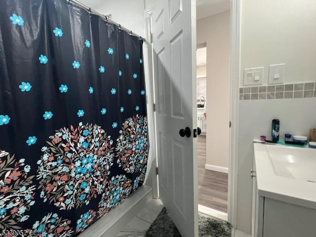 bathroom featuring curtained shower, vanity, and wood finished floors