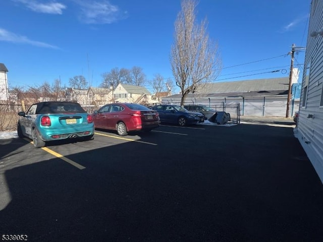 uncovered parking lot featuring fence