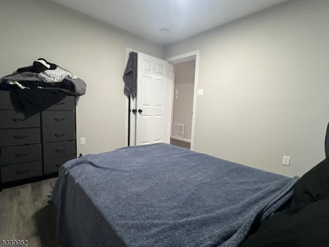 bedroom featuring visible vents and wood finished floors