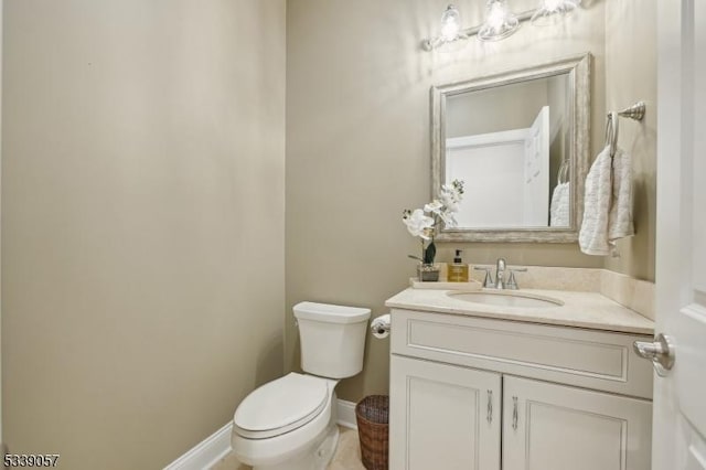 bathroom featuring vanity, toilet, and baseboards