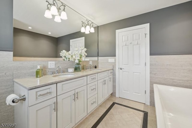 bathroom featuring a soaking tub, a sink, and tile walls