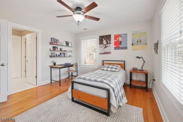 bedroom featuring ceiling fan, baseboards, and wood finished floors