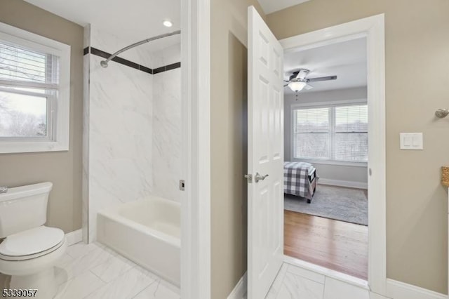 bathroom featuring ceiling fan, marble finish floor, toilet, and baseboards