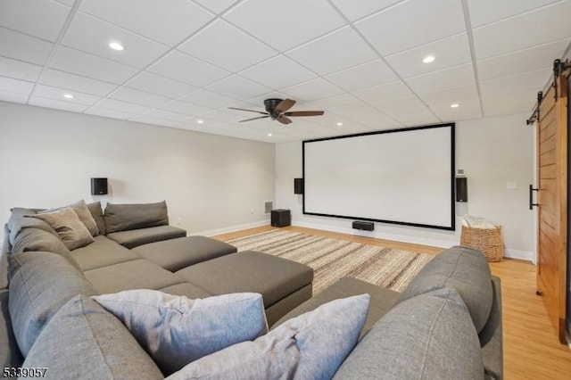 home theater room with light wood finished floors, a barn door, baseboards, and recessed lighting