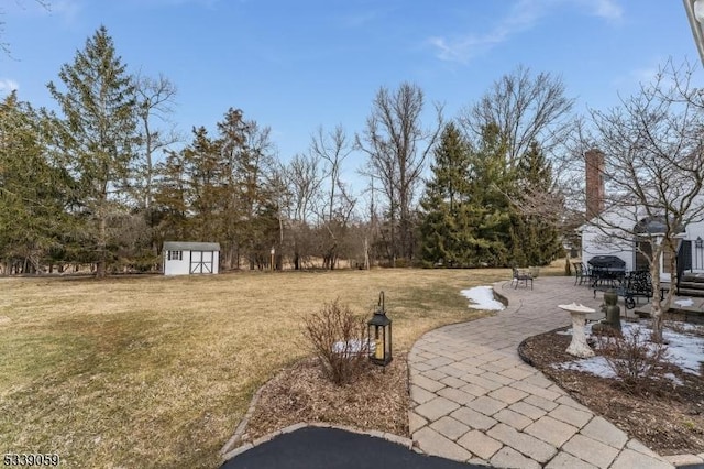 view of yard with an outbuilding, a shed, and a patio area