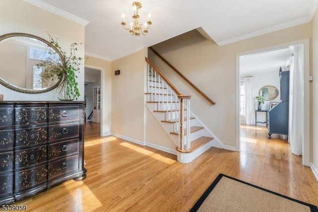 staircase featuring baseboards, ornamental molding, wood finished floors, and an inviting chandelier