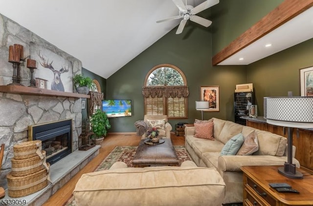 living area with ceiling fan, high vaulted ceiling, a fireplace, baseboards, and light wood-style floors