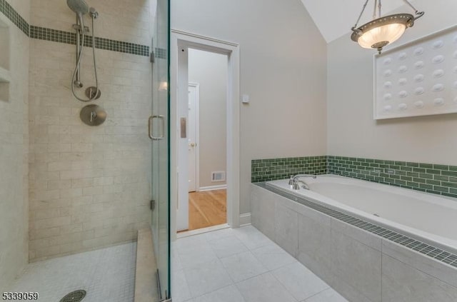 full bathroom featuring a garden tub, visible vents, vaulted ceiling, a shower stall, and tile patterned floors