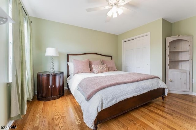 bedroom featuring light wood-type flooring, ceiling fan, and a closet