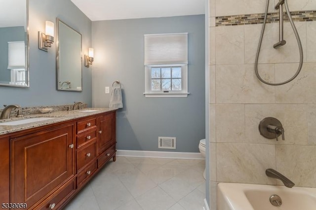 bathroom with toilet, a sink, visible vents, baseboards, and double vanity