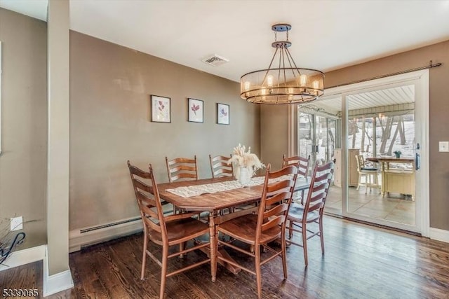 dining space with a notable chandelier, dark wood-type flooring, and a baseboard heating unit