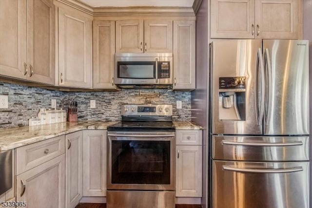 kitchen with light brown cabinets, tasteful backsplash, stainless steel appliances, and light stone counters