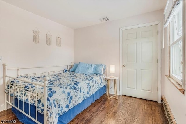 bedroom featuring a baseboard radiator and wood-type flooring
