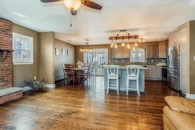 kitchen featuring dark hardwood / wood-style floors, stainless steel refrigerator with ice dispenser, a center island, and pendant lighting