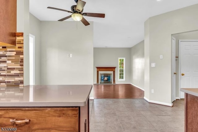 kitchen featuring ceiling fan, light tile patterned floors, and tasteful backsplash