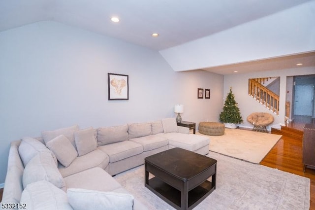 living area featuring stairs, light wood finished floors, vaulted ceiling, and recessed lighting