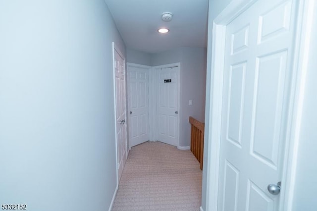 hallway with light carpet and baseboards