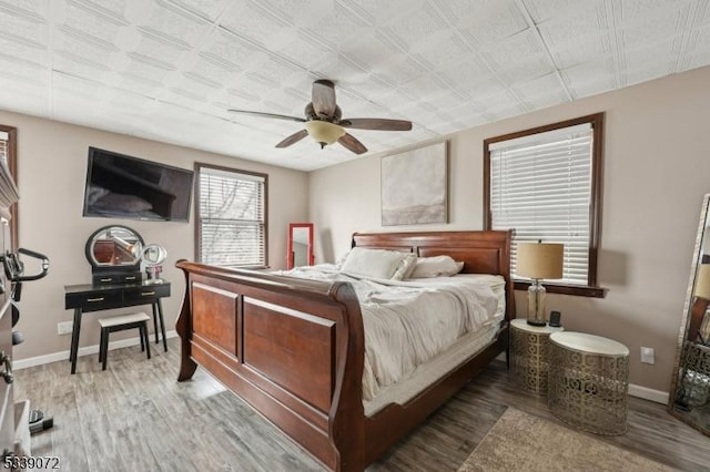 bedroom with a ceiling fan, light wood-type flooring, and baseboards