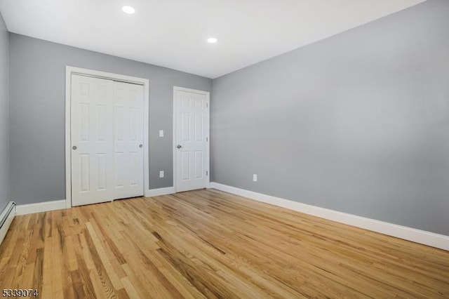 unfurnished bedroom with light wood-type flooring and a closet