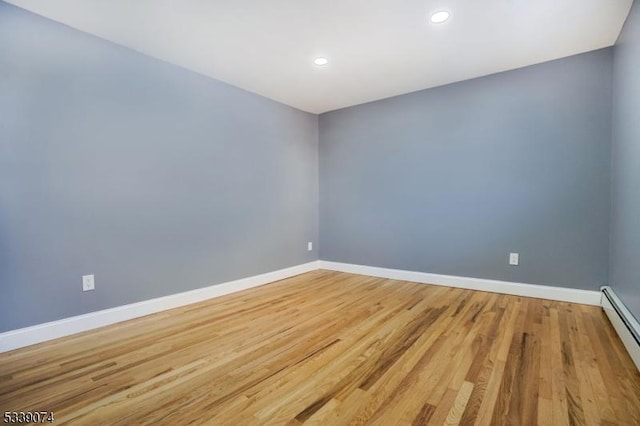 unfurnished room featuring light hardwood / wood-style flooring and a baseboard radiator