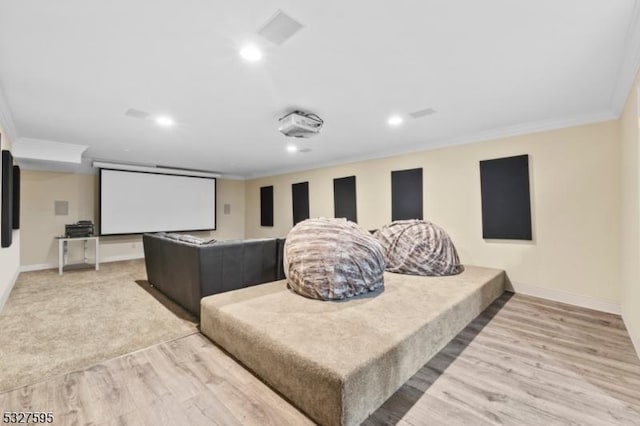 home theater with light wood-type flooring and crown molding