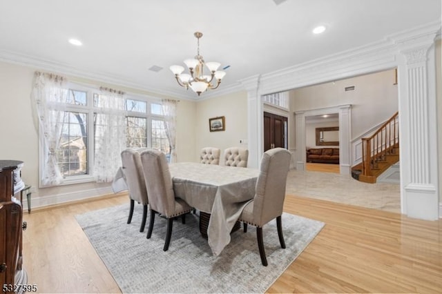 dining space featuring a notable chandelier, light hardwood / wood-style floors, and ornamental molding