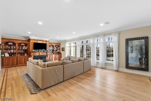 living room featuring light wood-type flooring and crown molding