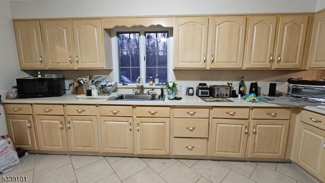 kitchen with sink, light brown cabinets, and light tile patterned floors