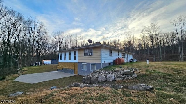 property exterior at dusk featuring a lawn and a patio area