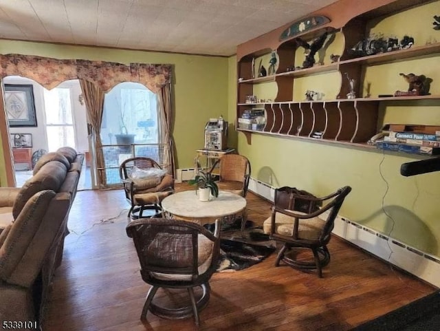 living area with hardwood / wood-style floors and baseboard heating