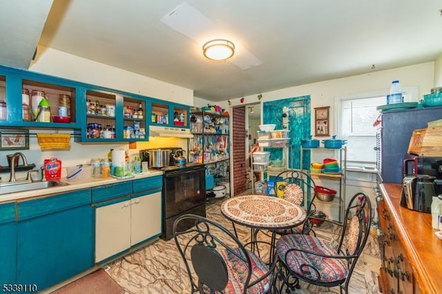 kitchen featuring light countertops, a sink, and black / electric stove