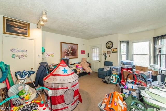 playroom with a textured ceiling and carpet flooring