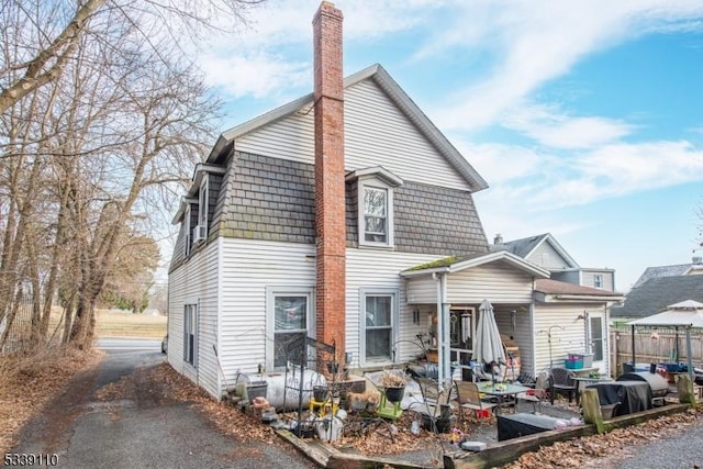 view of front of home featuring a chimney and fence