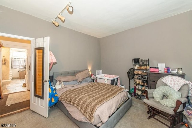 carpeted bedroom with rail lighting