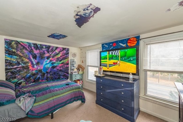 bedroom featuring carpet floors, multiple windows, and baseboards