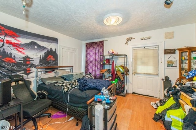 bedroom with a textured ceiling and wood finished floors