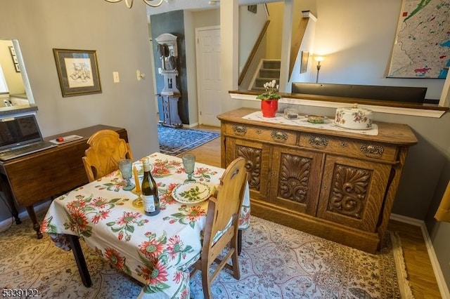 dining space featuring baseboards, stairway, and wood finished floors