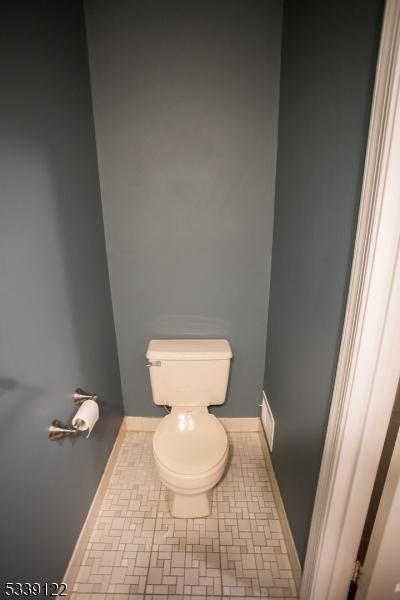 bathroom with baseboards and toilet